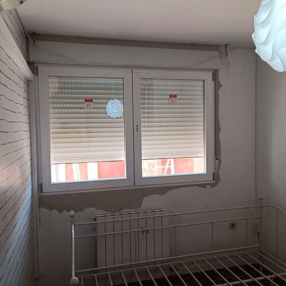 Ventana de doble hoja con persianas enrollables blancas