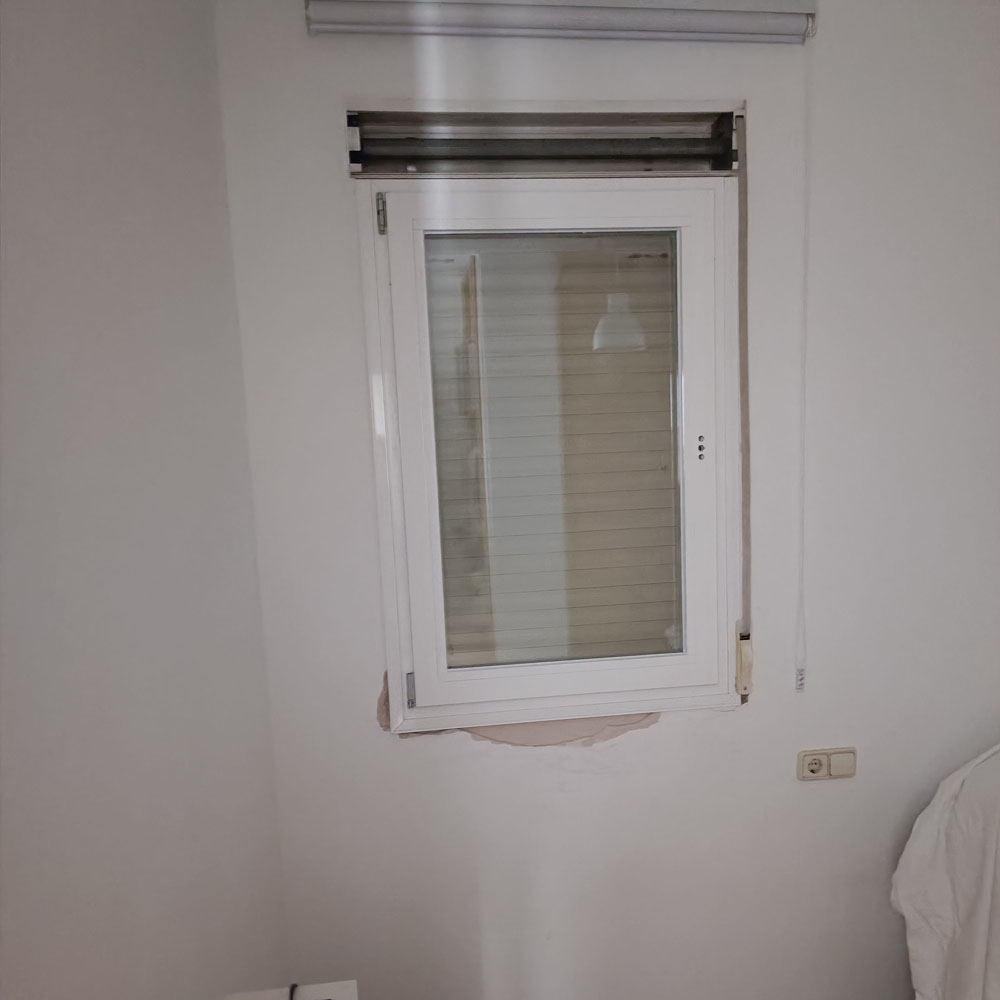 Ventana abatible blanca con persiana enrollable integrada