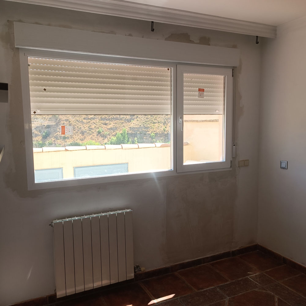 Ventana abatible blanca con persianas enrollables integradas