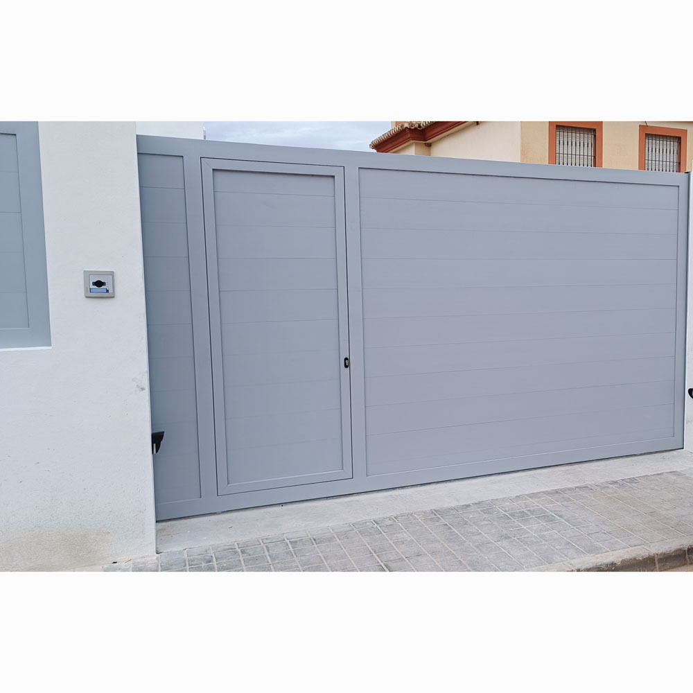 Portón de aluminio gris claro con puerta peatonal integrada