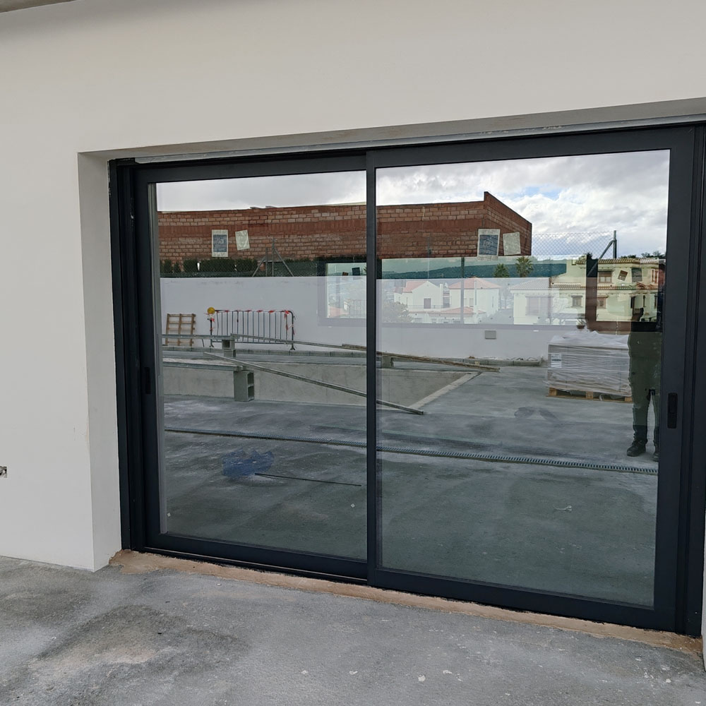 Puerta corredera de cristal y aluminio negro para exteriores